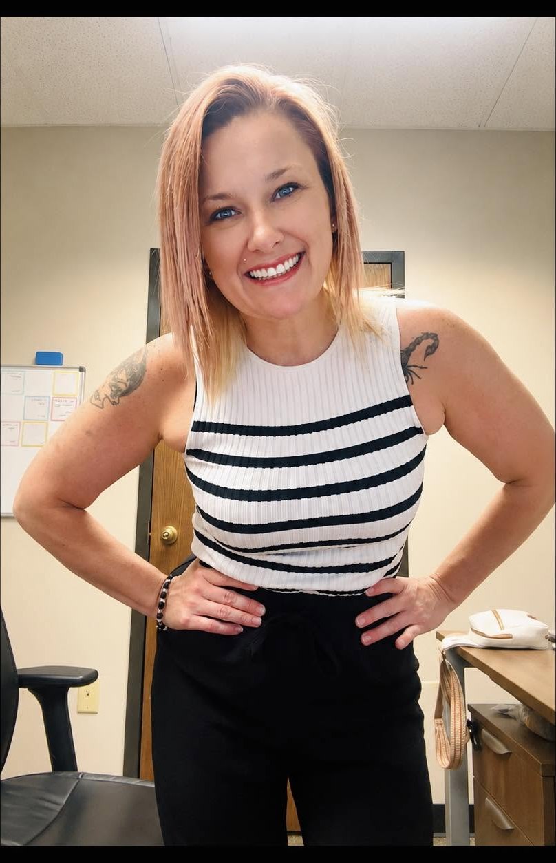 Britt St. Clair, hands on hips, smiling